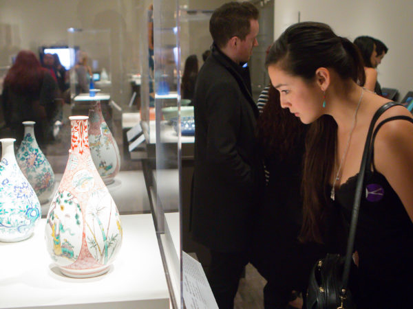 A woman looks at vases with flowers painted on them